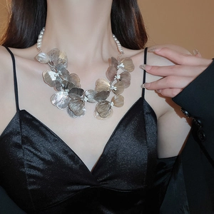 Detailed close-up of a silver floral petal necklace with elegant pearl chain strands