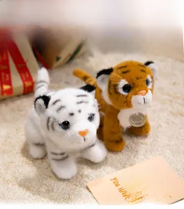 Detailed view of plush white and yellow tiger toys with blue eyes and toy tag