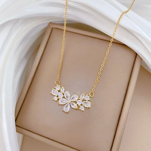 Elegant gold titanium steel necklace featuring a hollow zircon flower pendant on a box
