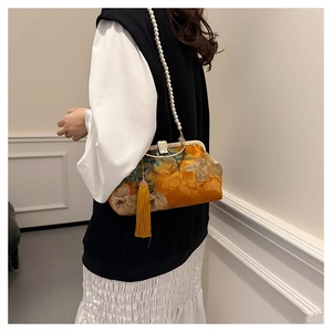 Detail of vintage yellow floral frame bag with pearl chain and long silk tassel