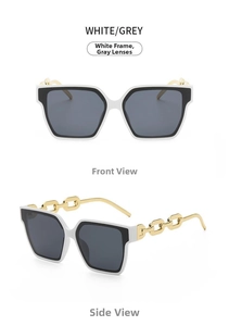 Detail of square sunglasses with white frames and bold gold chain link arms on white