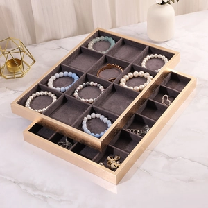 Dual-tier golden frame jewelry tray with grey velvet compartments for ring display