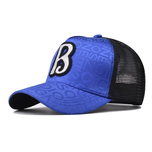Detail of blue and black mesh baseball cap featuring a large silver sequin letter B