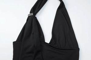 Close-up of black halter neck top with silver metal buckle and elastic knit fabric