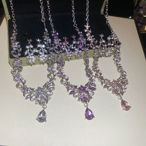 Detailed set of crystal flower and water drop pendant necklaces with matching earrings