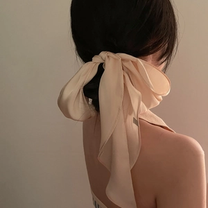 Elegant beige silk hair scarf tied in a large bow on model's hair with French vintage style