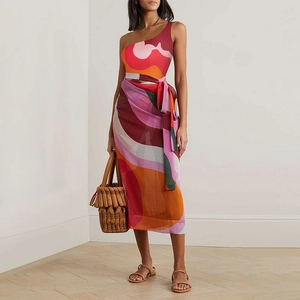Detail view of one-shoulder swimsuit with geometric wave print and matching wrap skirt