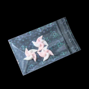 Detail of pink and white windmill resin charms in laser heart self-sealing bags