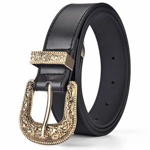 Detail of vintage black leather belt with ornate golden floral engraved metal buckle