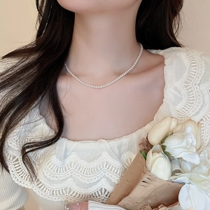 Elegant French-style pearl necklace worn by a model showcasing the delicate clavicle chain