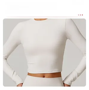 Détail d'un crop top de yoga beige à manches longues avec ourlet ajusté et tissu nervuré