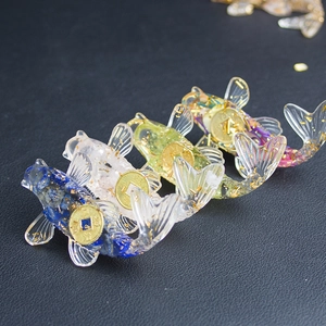 Detailed top view of four resin koi fish with gold foil and coins on black background