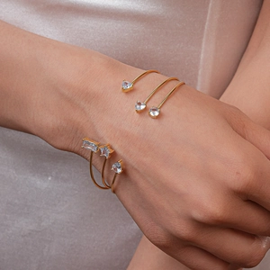 Détail de joncs dorés ajustables avec oxydes de zirconium étoiles sur tissu champagne