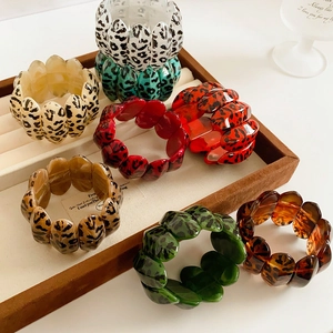 Close-up of leopard print resin bird nest hair clips in assorted colors on velvet tray