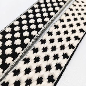 Close-up of thick woven shoulder straps with polka dots and cross star patterns