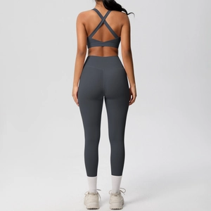 Vista trasera del conjunto de yoga gris oscuro con sujetador deportivo cruzado y leggings de talle alto