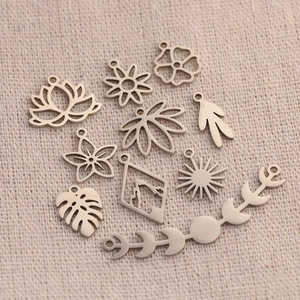 Polished silver stainless steel floral and botanical charms collection on linen background