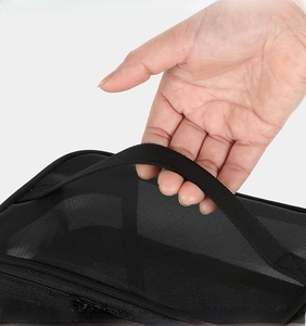 Close-up of the reinforced handle on a double-layer black mesh toiletry bag