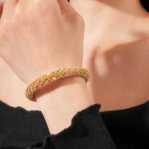 Détail d'un bracelet doré avec sertissage de diamants multi-rangs sur le poignet