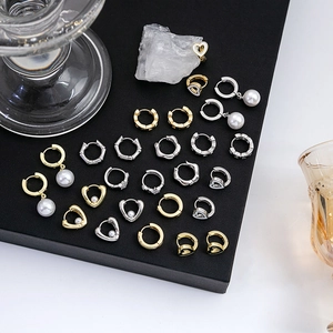 Collection de boucles d'oreilles cœur et perle avec zircon sur surface noire mate