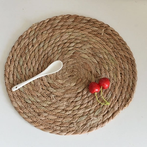 Detail of round woven seagrass placemat with natural textures and spiral craftsmanship
