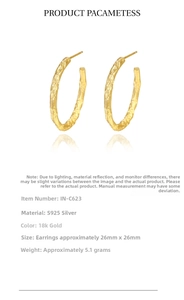 Detail of 925 sterling silver hoop earrings with a hammered 18k gold texture