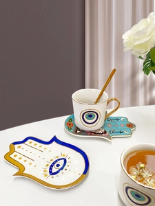 Sottocoppa Hamsa in ceramica con tazzina da caffè turco e cucchiaio d'oro su marmo