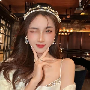 Detail of white pearl headband with gold rhinestone earrings and matching rings set