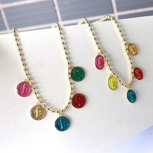 Detailed view of golden bead necklaces featuring multi-colored religious enamel pendants