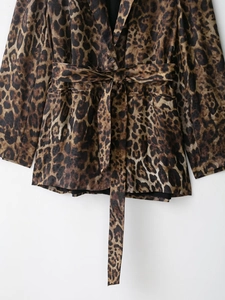 Dettaglio di un blazer classico con stampa leopardata che mostra cintura e tessuto pregiato