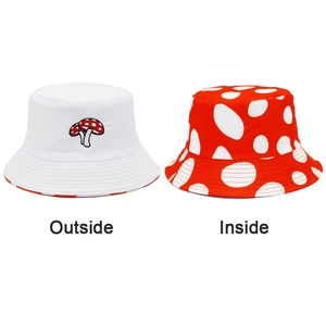 Detail of reversible mushroom bucket hat showing both red polka dot and white embroidered sides