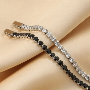 Close-up of stainless steel tennis bracelets with black and white cubic zirconia on silk