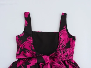 Detail of elegant back bow and pink jacquard pattern on a black sleeveless dress