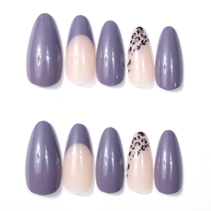 Detail of almond press-on nails with purple French tips and leopard patterns