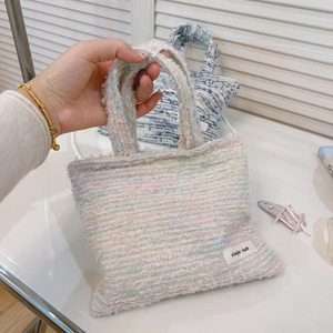 Dettaglio della trama in tweed colorato sulla mini borsa con etichetta semplice