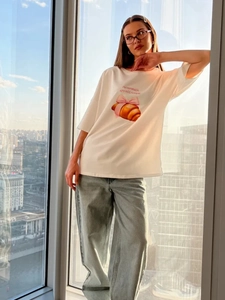 Λεπτομέρεια από βαμβακερό t-shirt με τύπωμα κρουασάν και μπλε τζιν παντελόνι