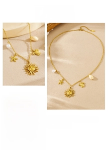 Detail of 18K gold-plated necklace with sun, turtle, starfish, shell and pearl charms