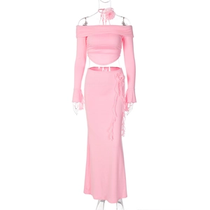 Detailed view of pink two-piece set featuring off-shoulder top and maxi skirt with flower detail