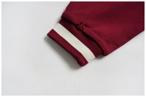Close-up of wine red ribbed cuff with white contrast stripe on athletic sweatshirt
