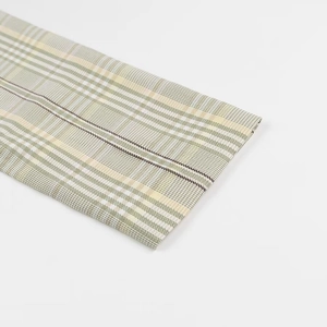 Close-up of green and beige plaid fabric texture on a professional casual blazer