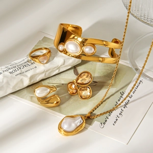 Detailed shot of vintage gold jewelry set with baroque pearls and amber crystals