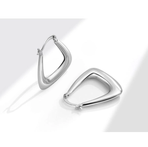 Macro shot of silver geometric triangle hoop earrings with a high-polished metallic finish