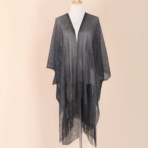 Detail of black shimmering mesh shawl with metallic threads and fringe trim on mannequin