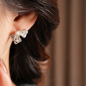 Gros plan de boucles d'oreilles papillon ajourées avec zircons cubiques scintillants