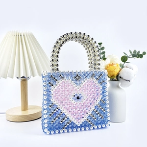 Detailed handmade beaded tote bag with a pink heart motif and evil eye bead centerpiece