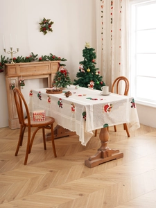 Detailed embroidery of Santa Claus and stockings on cream lace Christmas tablecloth