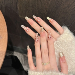Handmade cat-eye press-on nails with red fireworks and gold glitter in coffin shape