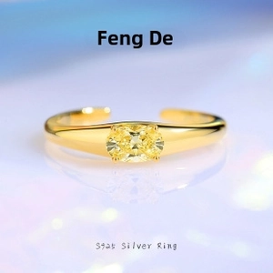 Macro detail of S925 silver ring featuring a golden band and oval yellow gemstone