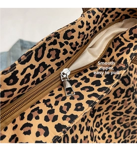 Détail de la fermeture éclair en métal argenté sur un sac cabas en toile léopard