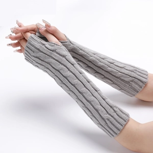 Close-up of light grey cable knit texture on long fingerless gloves for winter warmth